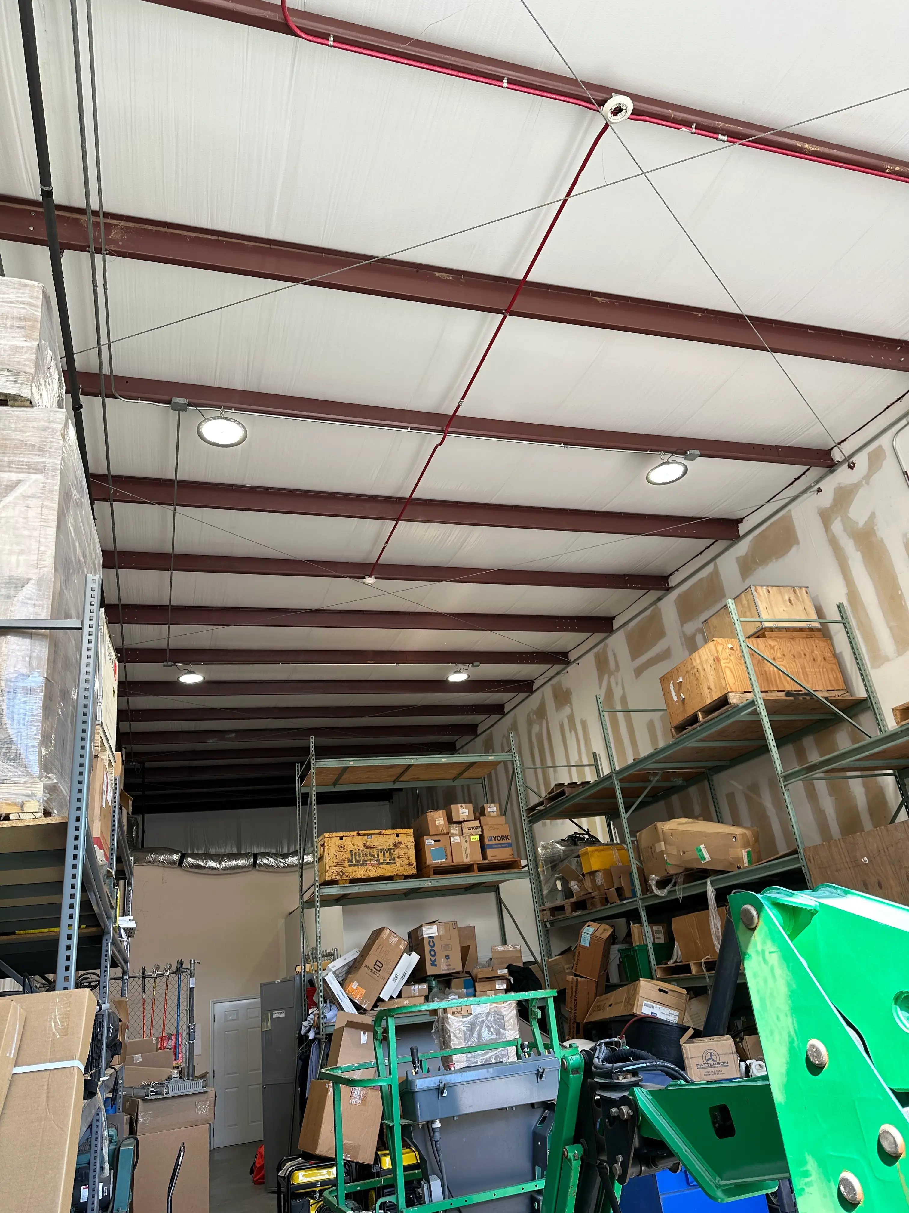 Illuminated round high-bay fixtures mounted along the ceiling of a commercial storage building